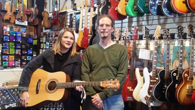 Trustee-Doug-Rat-Brooks-posing-with-ACCSs-Robin-Webb-showing-off-the-new-Cort-Acoustic-Guitar-and-starter-package-bought-at-Blue-Eagle-Music